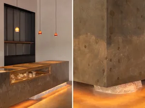 Industrial kitchen dining space with a countertop, sink, and dining table, illuminated by hanging lights