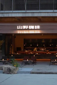 A modern Asian restaurant with a bar area and dining tables, featuring bottles and an inviting atmosphere