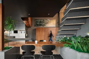 Cozy modern kitchen with a dining table surrounded by chairs, a cup on the table, and a focus on functionality and contemporary design elements