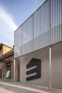 Modern building with a large metal wall and a black sign reading LEB, set against a concrete exterior with a sturdy and durable appearance