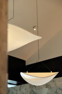 A modern black room with two metal lamps hanging from the ceiling, creating a minimalist atmosphere with a focus on the lamps as decorative elements