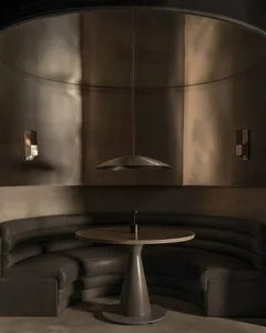 Dining room with a black and gold color scheme, featuring a dining table and chairs, two couches, and metallic elements