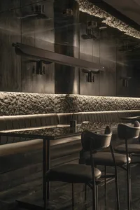 Modern restaurant bar with black leather chairs and tables, surrounded by a stylish and sophisticated atmosphere