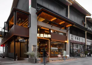 A modern Asian restaurant with a wooden interior, large glass window, and natural light, featuring chairs and a bench in a dining area