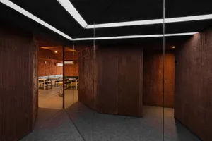 A warm and inviting room with wooden walls and floors, featuring a dining table and chairs, creating a cozy atmosphere