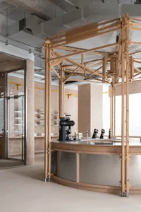 Warm and inviting coffee shop interior with a counter, sink, books, and wooden accents