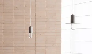 Interior space with a brick-patterned wall, two hanging lights, and a window allowing natural light