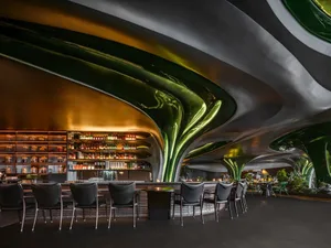 Upside-down view of a modern bar with chairs and tables, bottles on the tables and countertops
