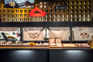 A modern restaurant with a black countertop, red triangle symbol, and various food items on display