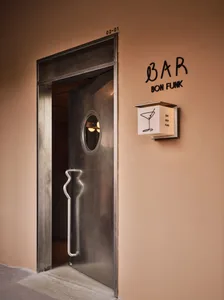 A metal door with a keyhole in a modern bar or restaurant setting