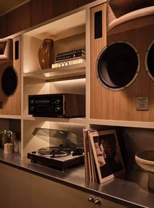 A cozy living area with a bookshelf, record player, and neatly arranged books, creating a warm and inviting atmosphere