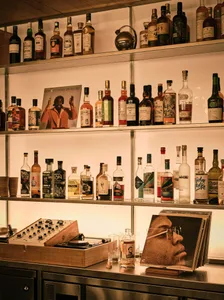 A well-stocked bar with various liquor bottles displayed on shelves in different shapes and sizes