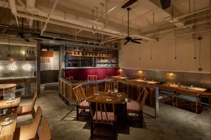 Cozy Asian restaurant interior with wooden tables, metal accents, and dim lighting
