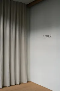 A white room with a linen curtain hanging on a wall, with no other objects or details visible