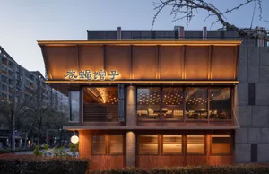 Cozy Asian restaurant with a wooden exterior, stone accents, and a warm atmosphere, featuring dining tables and natural light