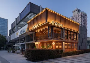 A modern Asian restaurant with a large wooden structure and glass elements, set against a well-lit interior with a warm and inviting atmosphere