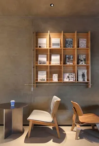 A calm and inviting library space with wooden bookshelves, chairs, and a collection of books