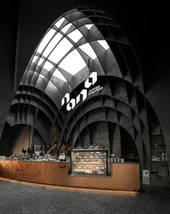 A modern coffee shop interior with a glass dome ceiling, natural light, and various decorative items