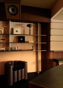 Cozy living space with a bookshelf, two couches, a chair, and various decorative items
