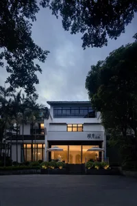 Asian-style house with a white facade, black trim, and outdoor umbrellas providing shade and ambiance