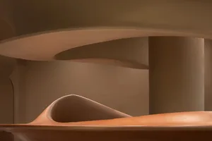 A minimalist interior space with a curved wooden wall as a focal point, featuring a modern and contemporary design style