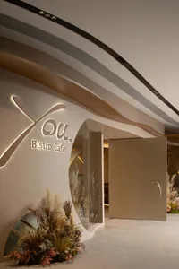Spacious bistro cafe with brown and white walls, potted plants, and a modern atmosphere