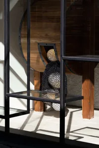 A cozy coffee shop interior with a wooden table featuring balls and a bowl, surrounded by warm and inviting elements
