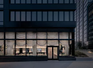 Elegant dining space with a black building facade, a large window, and a beautifully decorated interior with a dining table and chairs