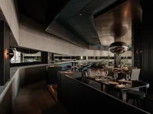 Modern dining area with wood and metal elements, wine glasses, and a sophisticated atmosphere