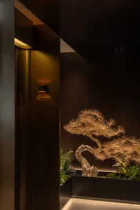 A warm and inviting living space with a large wooden tree sculpture as a centerpiece, placed in front of a doorway
