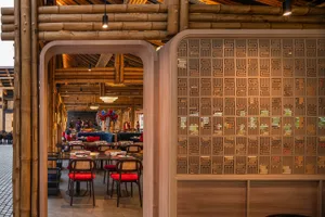 A warm and inviting restaurant interior with wooden walls and ceiling, featuring dining tables and chairs