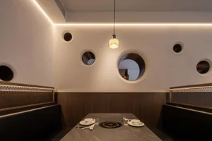 Empty restaurant dining area with multiple round tables and chairs, clean and inviting atmosphere
