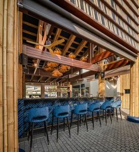 A relaxed bar area with a bamboo-themed counter and four chairs, perfect for socializing and enjoying drinks