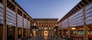 A classic building with a brick exterior and an open seating area with benches, surrounded by a pleasant atmosphere