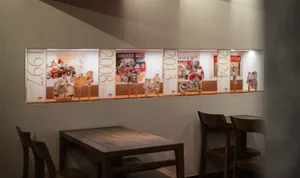 Warm and inviting restaurant interior with wooden tables and chairs, multiple dining tables and chairs, and a focus on comfort