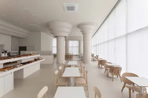 Empty restaurant interior with white walls, dining tables, and chairs, featuring a clean and inviting atmosphere