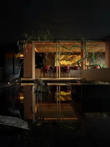 Elegant dining space with wooden furniture, well-lit with natural and artificial light, and comfortable seating arrangements