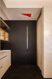 A narrow and dark hallway with a black doorway, flanked by two doors on either side
