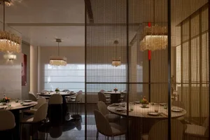 Sophisticated dining space with wooden furniture, wine glasses, and well-lit surroundings