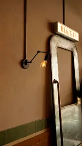 Interior space with a metal-framed doorway and light fixture, leading to a room in the background