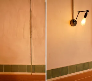 Bathroom with green tile walls and white tile walls, featuring a sink and lights