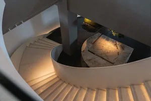 A rendered image of a grand spiral staircase with a white marble appearance, set in a luxurious and elegant atmosphere