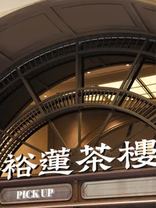 A photo of an Asian building with a large archway entrance, metal railings, and two staircases leading upwards