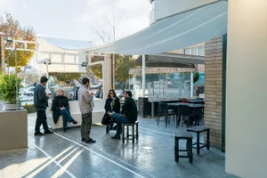 A casual dining space with people seated at tables and chairs, surrounded by cozy furniture and a social atmosphere
