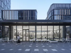 A modern dining space with several tables and chairs arranged in a commercial setting, creating a social atmosphere for dining and gathering