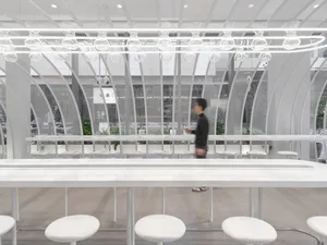 Modern restaurant interior with a long bar, dining tables, and comfortable seating for guests