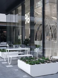 A bright and inviting indoor space with a large glass window, benches, and potted plants
