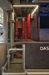 Industrial area with a large pipe system featuring red and silver pipes, fire hydrants, and a possible water storage or distribution setting