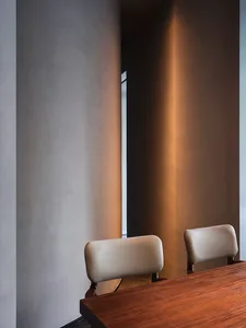 Dimly lit room with two chairs, one on the left and one on the right, in an empty space