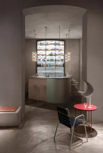 A stylish bar area with a silver counter, wine rack, chairs, and dining tables, creating a welcoming space for socializing and dining